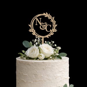 May include: A white ceramic mug with a black handle and the text "But First, Coffee" in a bold, black font. The mug is set against a blurred background. The mug appears to be approximately 10 cm tall.