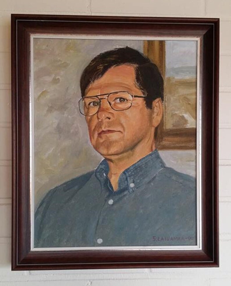 May include: A framed oil painting of a man wearing glasses and a blue shirt. The painting is signed "S. Laivama-O."