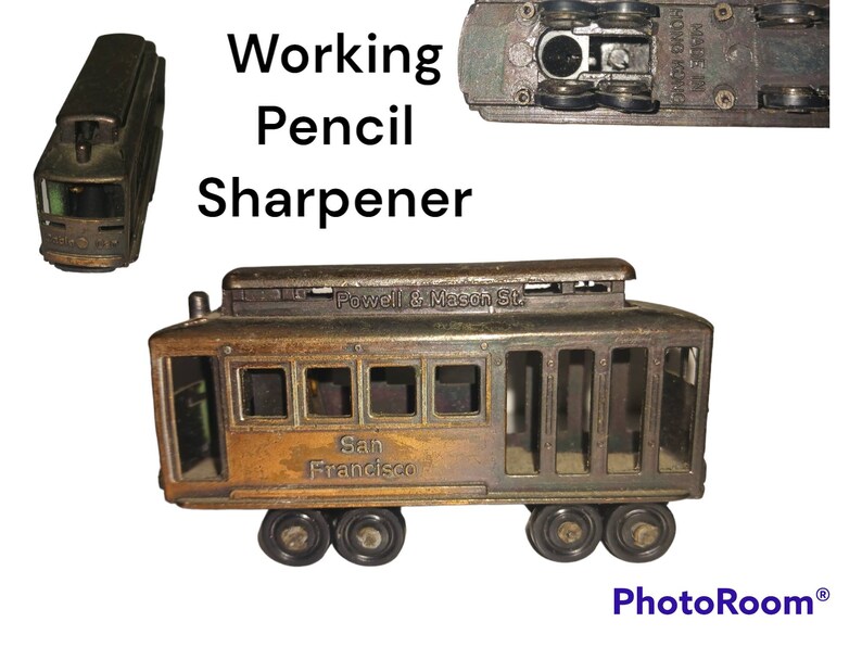 May include: A vintage metal pencil sharpener shaped like a San Francisco cable car. The sharpener is brown and has the words "Powell & Mason St." and "San Francisco" on the side. It has a working pencil sharpener mechanism.