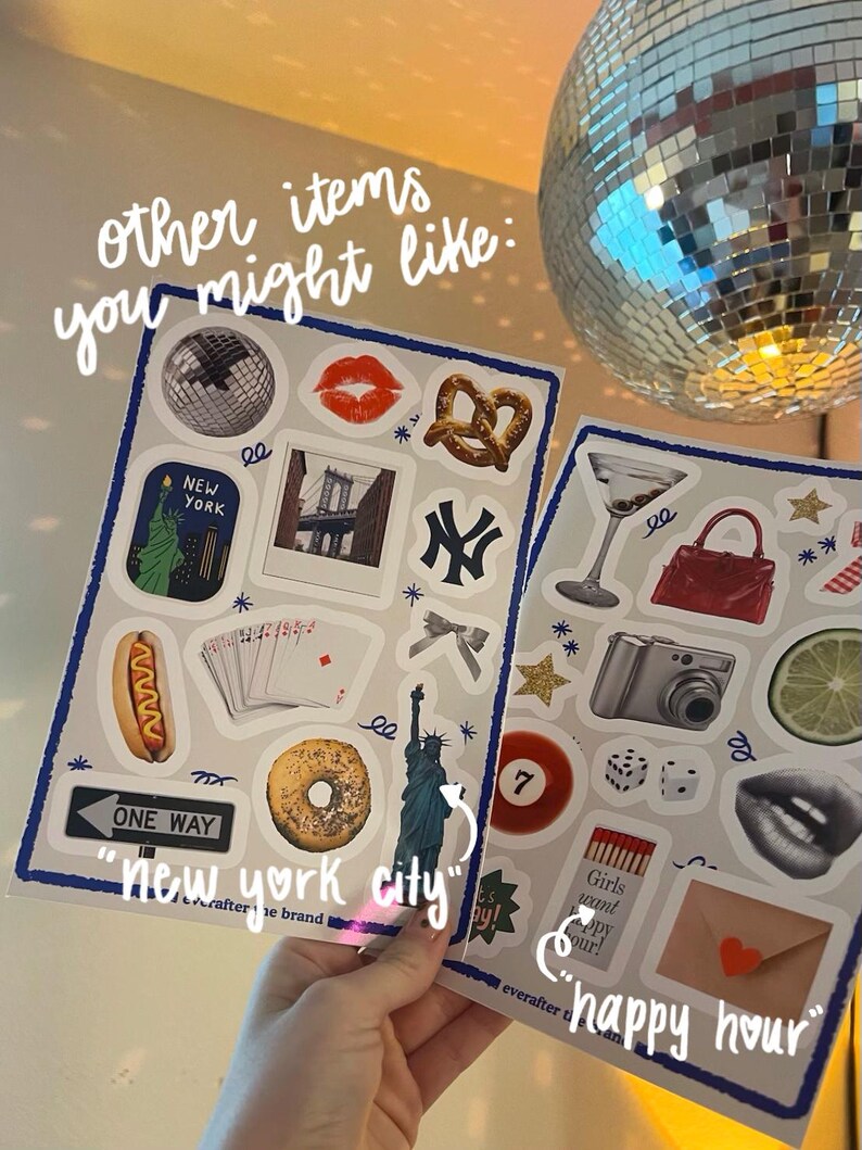 Pu&ograve; includere: Due fogli di adesivi con varie illustrazioni. Un foglio presenta una palla da discoteca, labbra, un pretzel e monumenti di New York. L'altro include un bicchiere da Martini, una fotocamera e dadi. Il testo sui fogli recita "new york city" e "happy hour".