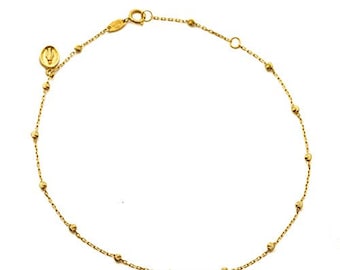 May include: A gold chain bracelet with small round beads. The bracelet has a clasp and a small charm.