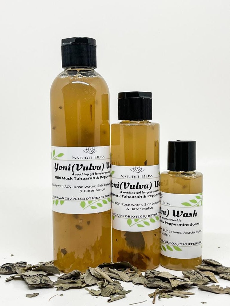 May include: Three bottles of clear liquid with brown labels. The largest bottle is labeled "Yoni (Vulva) Wash" with the text "Mild Musk Tahaarah & Peppermint Scent". The middle bottle is labeled "Yoni (Vulva) Wash" with the text "Musk Tahaarah & Peppermint Scent". The smallest bottle is labeled "Yoni (Vulva) Wash" with the text "Peppermint Scent". All three bottles have black caps.