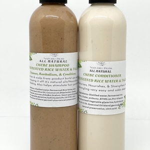 May include: Two brown plastic bottles with black caps. The bottles are labelled "Naturel Bliss All Natural Chebe Shampoo Fermented Rice Water & Tall" and "Naturel Bliss All Natural Chebe Conditioner Fermented Rice Water & Tall". The bottles are filled with a light brown and white liquid.