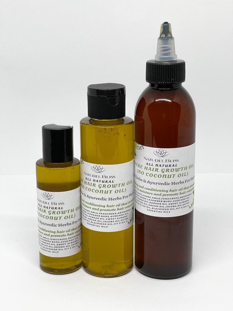 May include: Three glass bottles of hair growth oil with black caps and labels. The labels are white with black text and list the ingredients and benefits of the oil. The bottles are on a white background.