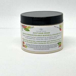 May include: A white jar with a black lid labeled "Deep Hair Mask (With Fermented Rice Water & Tallow Fat)". The label also includes the text "All Natural" and lists the ingredients.