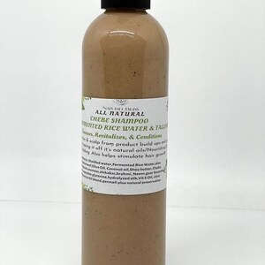 May include: A brown plastic bottle of all-natural chebe shampoo with fermented rice water and tallow. The bottle has a black cap and a white label with the product name and ingredients.