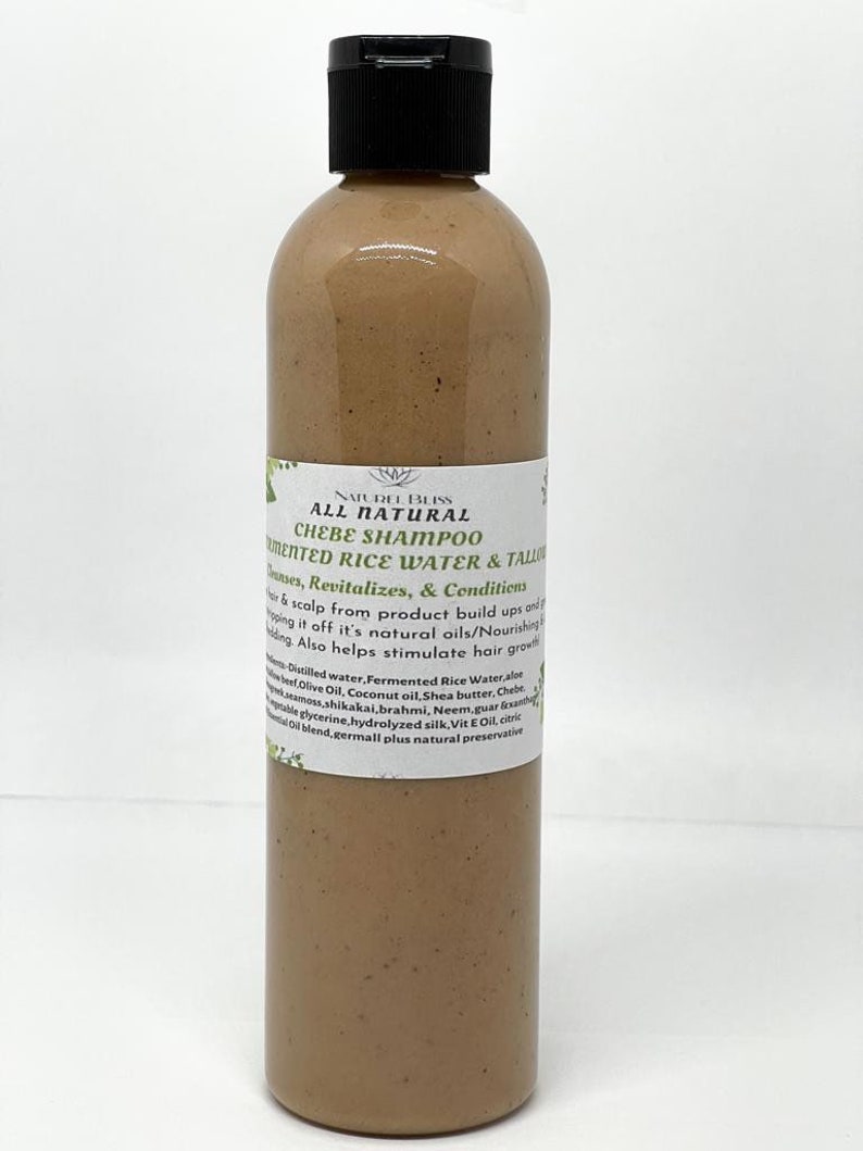May include: A brown plastic bottle of all-natural chebe shampoo with fermented rice water and tallow. The bottle has a black cap and a white label with the product name and ingredients.
