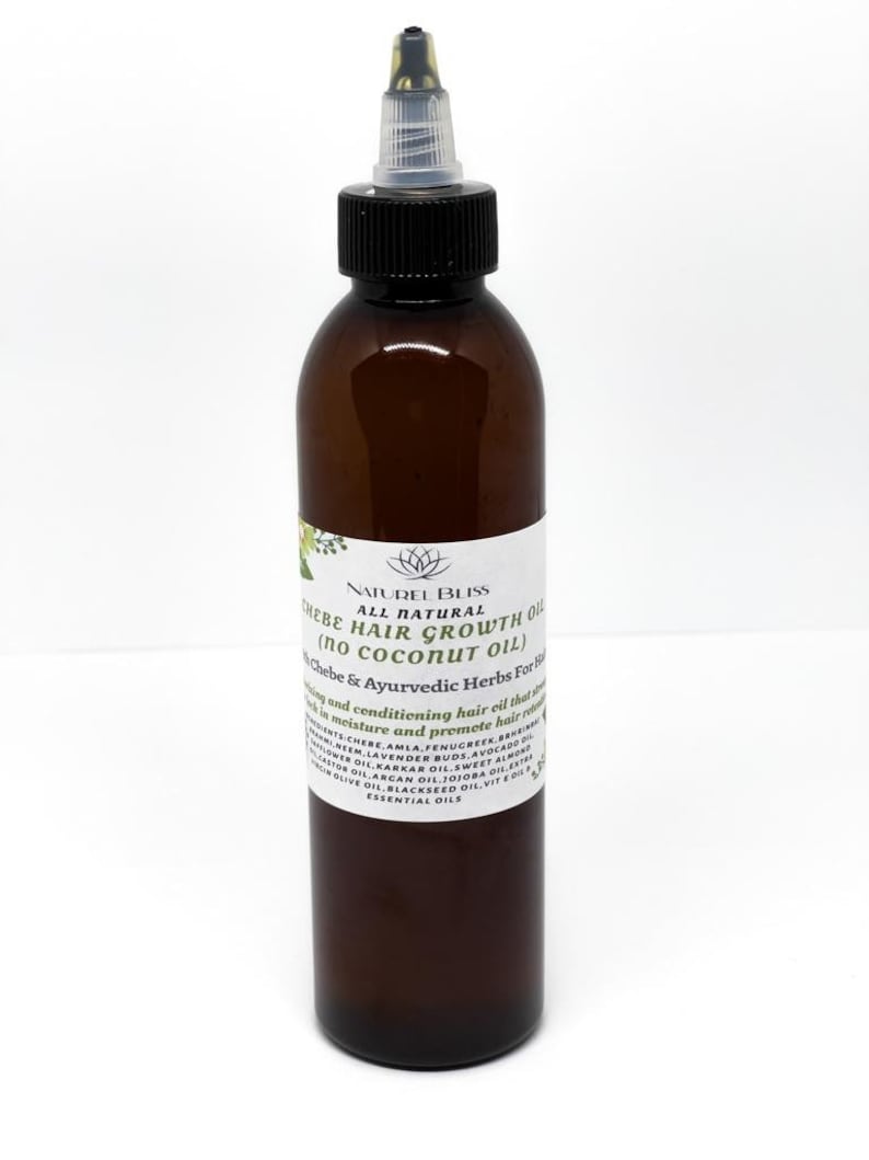 May include: A brown glass bottle with a black cap and a clear dropper. The bottle is labelled "NATUREL BLISS ALL NATURAL CHEBE HAIR GROWTH OIL (no coconut oil) Chebe & Ayurvedic Herbs For Hair".