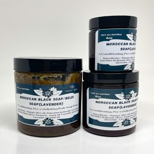K&ouml;nnte beinhalten: Drei Glasbeh&auml;lter mit marokkanischer schwarzer Seife mit Lavendel. Die Beh&auml;lter sind mit dem Produktnamen, den Inhaltsstoffen und der Gr&ouml;&szlig;e beschriftet. Die Beh&auml;lter stehen auf einer wei&szlig;en Oberfl&auml;che.