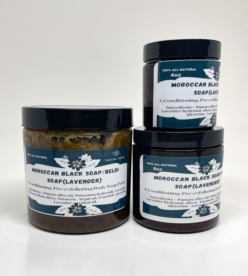 K&ouml;nnte beinhalten: Drei Glasbeh&auml;lter mit marokkanischer schwarzer Seife mit Lavendel. Die Beh&auml;lter sind mit dem Produktnamen, den Inhaltsstoffen und der Gr&ouml;&szlig;e beschriftet. Die Beh&auml;lter stehen auf einer wei&szlig;en Oberfl&auml;che.