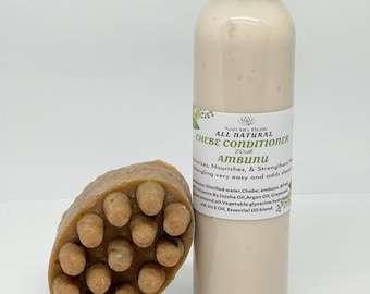 May include: A white plastic bottle with a black lid and a label that reads "All Natural Chebe Conditioner Zouh Ambunu" and a brown bar of soap with a textured surface.