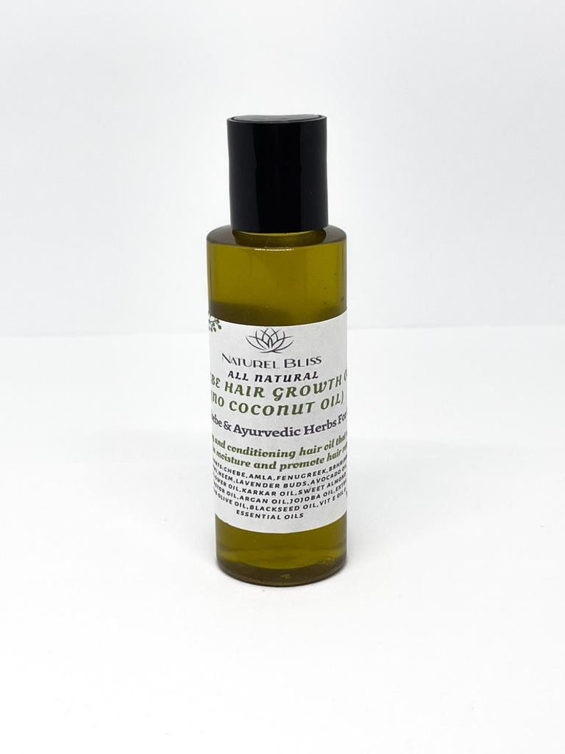 May include: A clear glass bottle with a black cap filled with a yellow liquid. The bottle label reads "NATUREL BLISS ALL NATURAL BE HAIR GROWTH no COCONUT OIL be & Ayurvedic Herbs For" and lists ingredients including amla, fenugreek, lavender buds, avocado oil, argan oil, jojoba oil, blackseed oil, sweet almond oil, karkar oil, and essential oils.