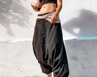 May include: Black harem pants with a patterned fabric belt. The pants have a loose, flowing fit and are made of a soft, comfortable fabric.