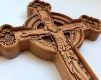 Puede incluir: Una cruz celta de madera con una figura tallada de Jesucristo. La cruz está intrincadamente detallada con un halo circular alrededor de la figura.