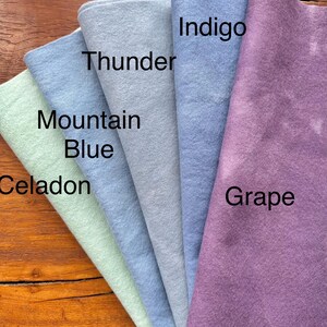 May include: Five different colors of felt fabric swatches, from left to right: Celadon, Mountain Blue, Thunder, Indigo, and Grape.