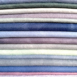 May include: A stack of 20 different colored felt fabric squares. The colors range from light to dark shades of blue, purple, pink, and gray.