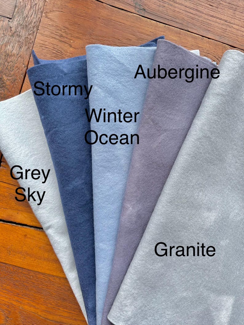 May include: Five fabric swatches in different shades of blue and gray. The swatches are labeled "Grey Sky", "Stormy", "Winter Ocean", "Aubergine", and "Granite".