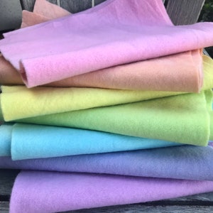 Confezioni arcobaleno in feltro di lana. Tinte a mano in colori pastello o vivaci. Confezioni da 7 colori. Il formato intero è 30 x 30 cm, mentre quello ridotto è 15 x 30 cm.