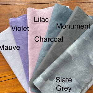 May include: A collection of six fabric swatches in various shades of purple, gray, and blue. The swatches are labeled "Mauve", "Violet", "Lilac", "Charcoal", "Monument", and "Slate Grey".