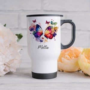 May include: White travel mug with a black handle and lid. The mug features a watercolour design of two colourful butterflies and the name "Mollie" in a script font. The design includes purple berries and green leaves.