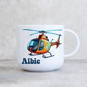 May include: White ceramic mug featuring a cartoon helicopter design and the name "Albie" printed on the front.