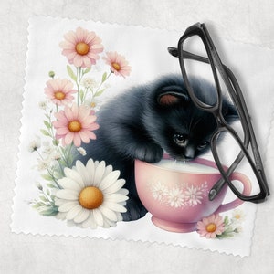 May include: A black kitten with white paws drinks milk from a pink teacup with floral designs. The kitten is surrounded by pink and white flowers. A pair of black eyeglasses is lying on the white background.