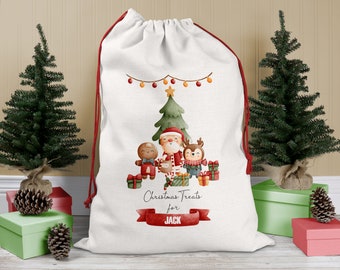 May include: White Christmas gift bag with red drawstring, featuring a watercolour illustration of Santa Claus, a gingerbread person, and a reindeer with presents. The bag has the text "Christmas Treats for JACK" printed on it.