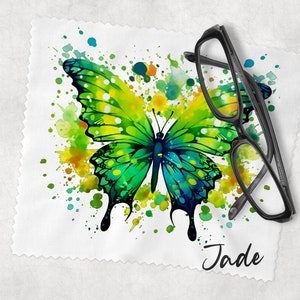 May include: A white microfiber cleaning cloth with a green and blue watercolor butterfly design and colorful paint splatters. The cloth has the name "Jade" written in cursive at the bottom.
