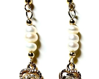 Earrings of Cultured Pearls and 14 karat gold balls.  Gold plated sterling silver hooks.  Metal heart cage encases cubic zirconia gemstone.