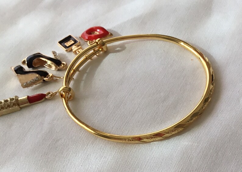 Frankly female 18 karat gold heavily plated stainless steel bangle bracelet with decorative carvings.