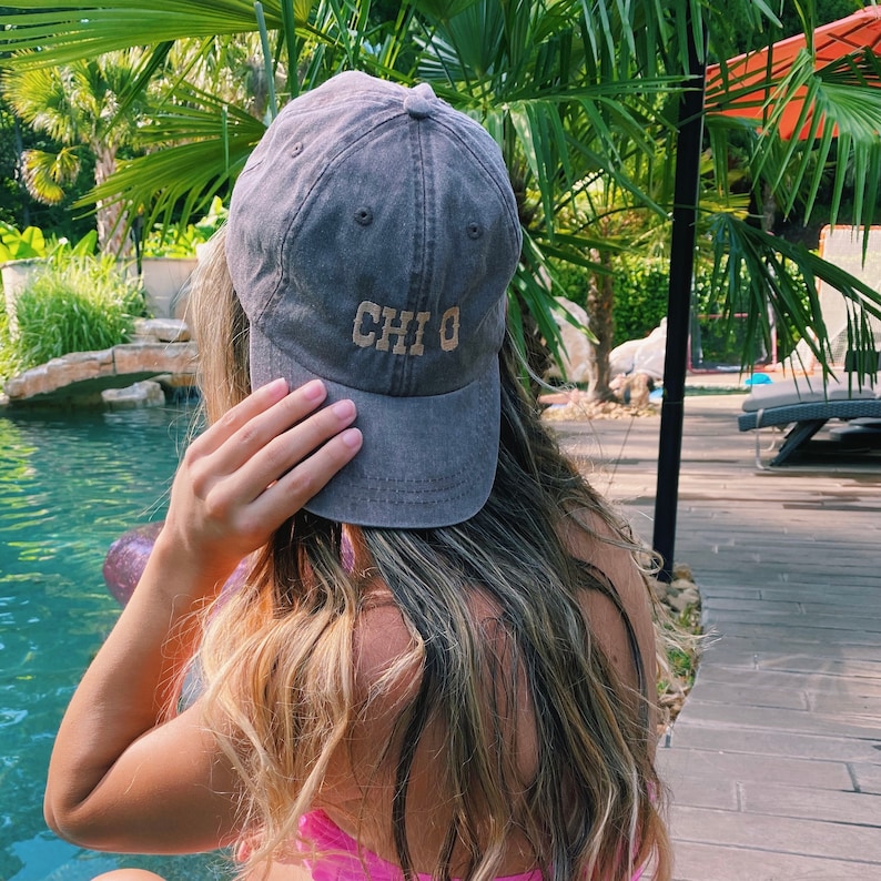 Peut inclure: Une casquette de baseball gris fonc&eacute; avec le mot "CHIO" brod&eacute; en brun clair sur le devant.