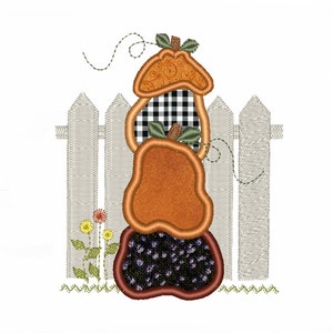 May include: A stack of three orange pumpkins with black and white checkered fabric and a brown base, in front of a white picket fence with green grass and flowers.
