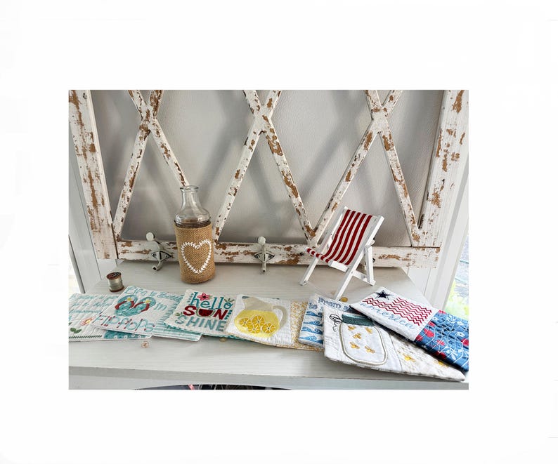 Pu&ograve; includere: Una collezione di oggetti decorativi a tema estivo, tra cui una bottiglia di vetro con un cuore di juta, una sedia a sdraio in miniatura a strisce rosse e bianche e sottobicchieri in tessuto. I sottobicchieri presentano disegni di limoni, pesci e la bandiera americana.