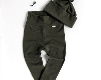 May include: A green baby outfit set with a matching hat. The pants are leggings and the hat has a knot on top.