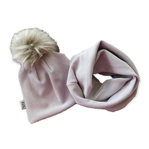 May include: A light gray ribbed knit beanie with a fluffy faux fur pom pom and a matching ribbed knit infinity scarf.