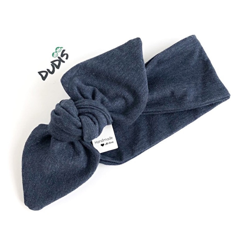 Puede incluir: Una diadema azul oscuro anudada con una etiqueta blanca que dice "Handmade with love".