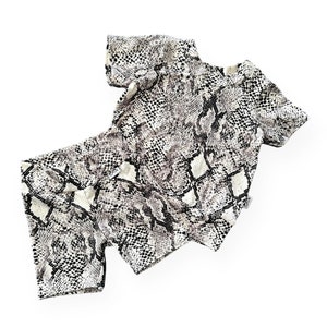 May include: A white and black snakeskin print crop top with short sleeves.