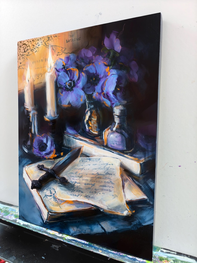 May include: An oil painting depicts a still life with a dark, moody aesthetic. It features lit candles, purple flowers in glass bottles, a book with a dagger, and handwritten notes. The color palette includes deep blues, purples, and warm yellows.