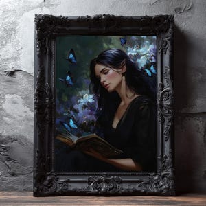 Può includere: Un'opera d'arte incorniciata in una cornice nera ornata raffigura una donna con i capelli scuri che legge un libro, circondata da farfalle blu e fiori. Il dipinto ha un tema fantasy.