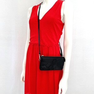 Model wearing black Moomin leather crossbody bag with Primadonna’s horse embossed detail, adjustable shoulder strap purse, RFID blocking wallet clutch.