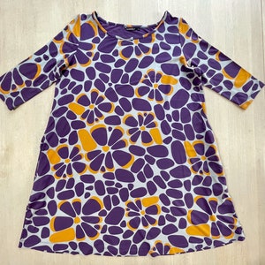 Marimekko dress featuring bold abstract floral print in purple, orange, and grey, 3/4 sleeve, made in Finland, cotton jersey tunic style.
