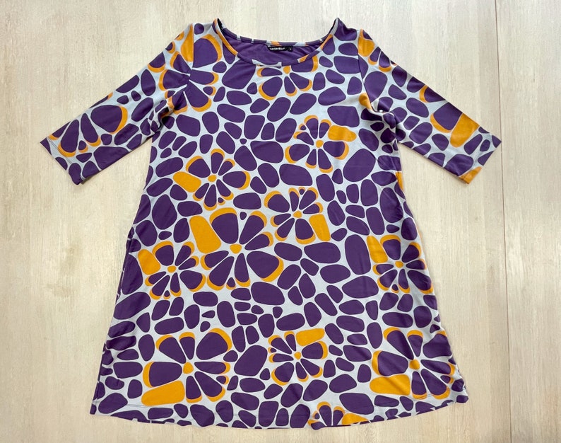 Marimekko dress featuring bold abstract floral print in purple, orange, and grey, 3/4 sleeve, made in Finland, cotton jersey tunic style.