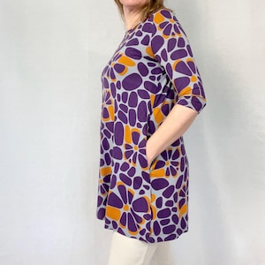 Marimekko tunic dress with purple and orange floral mod print, 3/4 sleeves, mid-length A-line cut, vintage Finland designer style.