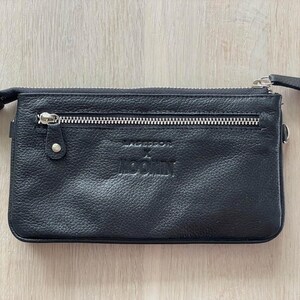 Pode incluir: Carteira de couro preta com fecho de correr e o texto "Moschino" em relevo na frente.