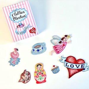 May include: A collection of embroidered patches, including a flamingo, angel, heart with "LOVE" banner, cat, Russian doll, cupcake, and teacup. A box of "Clothes Plasters" with the text "No More Holes!" is also present.