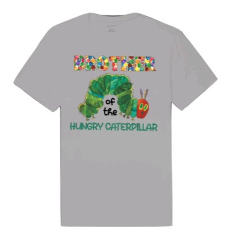 Puede incluir: Camiseta gris con un gr&aacute;fico colorido de "Hermano de la Oruga Hambrienta". La oruga es verde y tiene una cabeza roja con dos antenas.