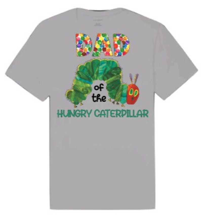 Puede incluir: Camiseta gris con un gr&aacute;fico colorido de "DAD" y una oruga verde con el texto "of the HUNGRY CATERPILLAR" debajo.
