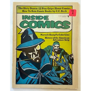 Peut inclure: Une couverture de bande dessinée vintage représentant un homme en cape et chapeau bleus, tenant une cigarette. La couverture est jaune avec du texte noir qui dit "Inside Comics" et "Marvel's Kung Fu Color Line".