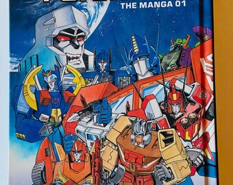 Transformers The Manga 01 Viz Media Couverture rigide, première impression février 2020 Ban Magami Masumi Kaneda 15,4 x 20,2 cm Comme neuf