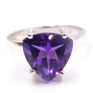 Könnte beinhalten: Ein silberner Ring mit einem großen, dreieckigen, violetten Amethyst-Edelstein.